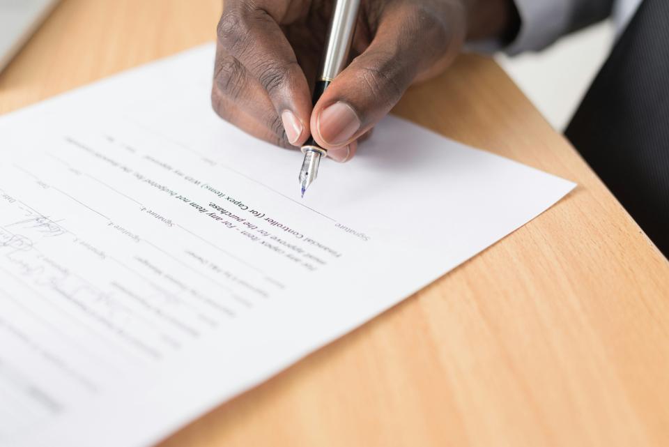 Hand schreibt auf Dokument